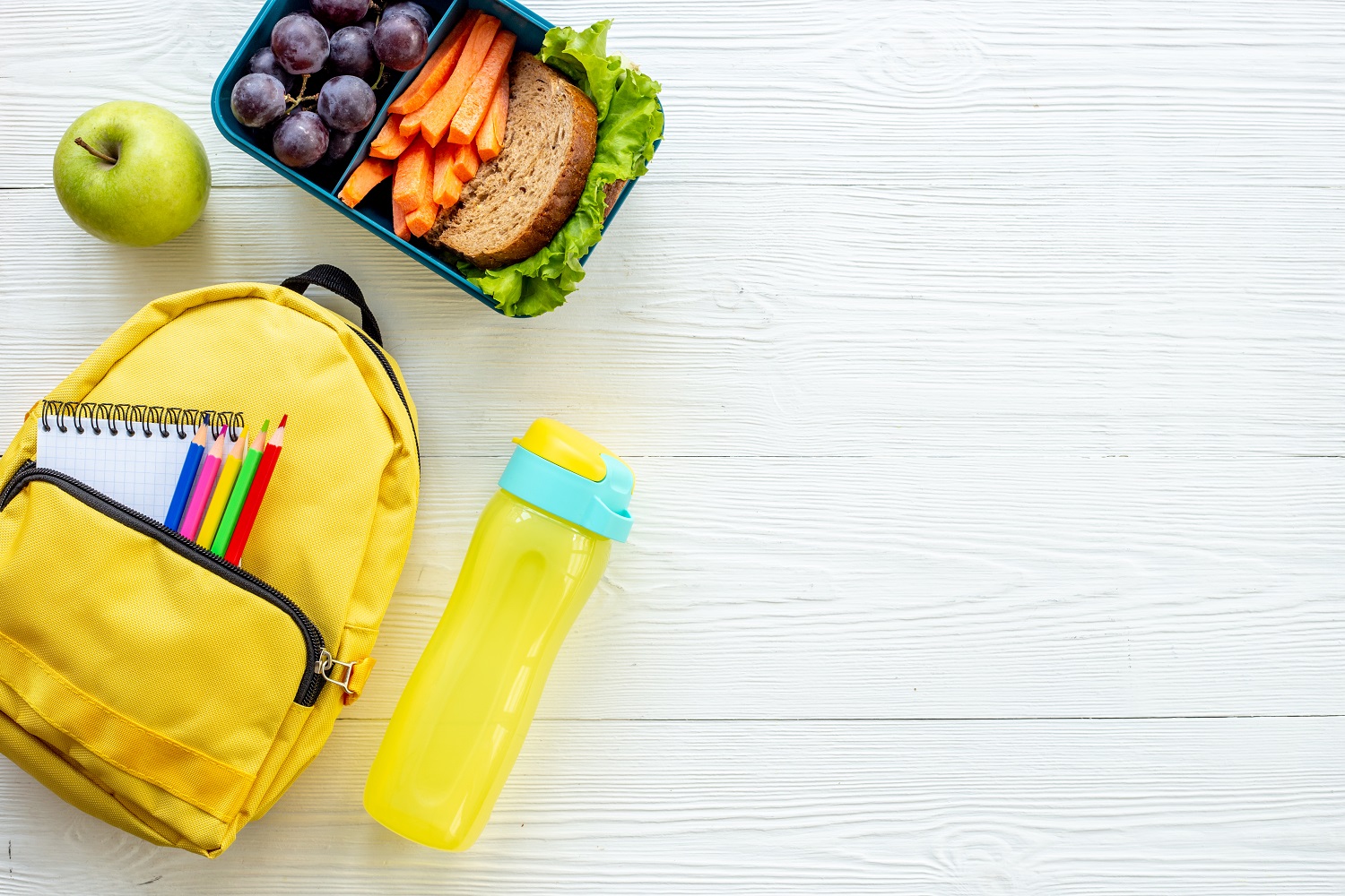 Healthy school lunch box with fruits and backpack, top view